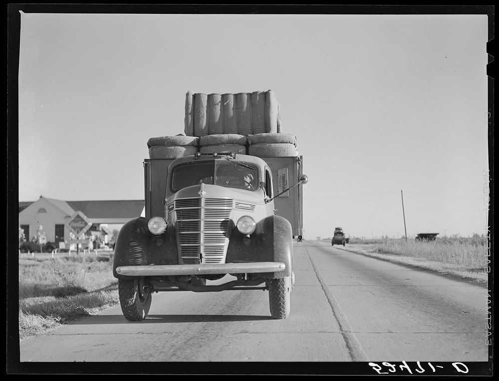 Truck with bales of cotton from Hopson Planting Company gin going up highway to warehouse near Clarksdale, Mississippi…