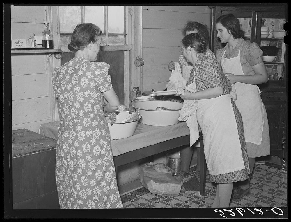Mrs. Fred Wilkins and other women of the Wilkins clan washing dishes in her kitchen after large dinner for the men who were…