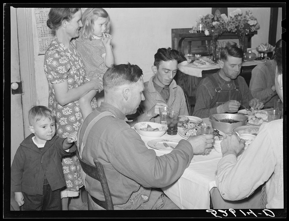 [Untitled photo, possibly related to: Mrs. Fred Wilkins passing cake to the men at dinner on corn-shucking day. Tallyho…