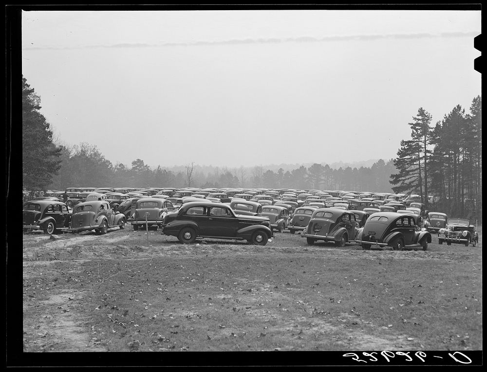 Cars parked in field near Duke University Stadium on day of Duke-Carolina football game. Durham County, North Carolina.…
