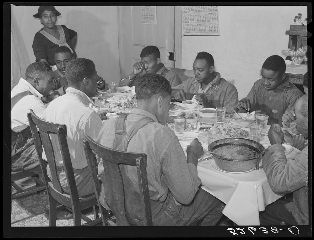 The  tenants and neighbors eating dinner after the white men have finished on day of corn-shucking at Mrs. Fred Wilkins'…