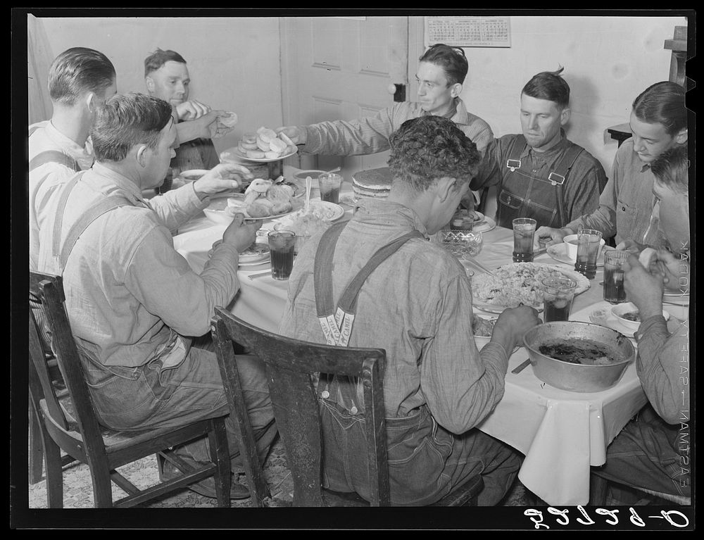 Men of the Wilkins clan eating dinner on cornshucking day at home of Mrs. Fred Wilkins. Tallyho, near Stem, Granville…