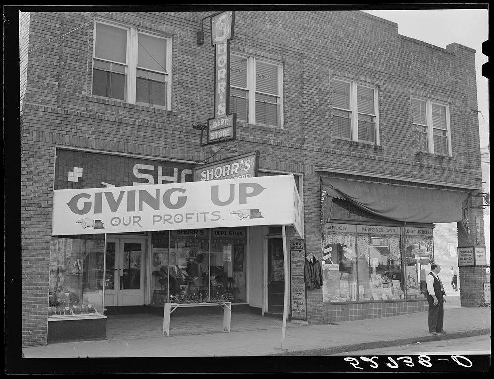 Signs on store fronts advertising sales during tobacco auction season in Zebulon, North Carolina. Sourced from the Library…