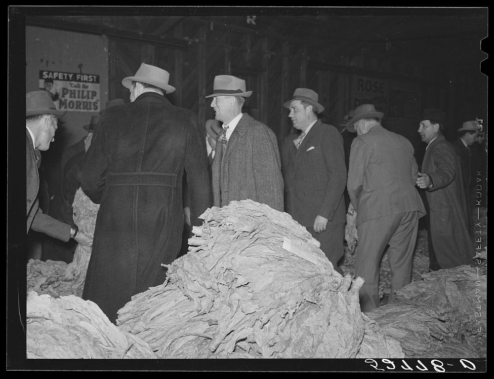 [Untitled photo, possibly related to: Farmers listening to sales talk of patent medicine vendor in warehouse during tobacco…