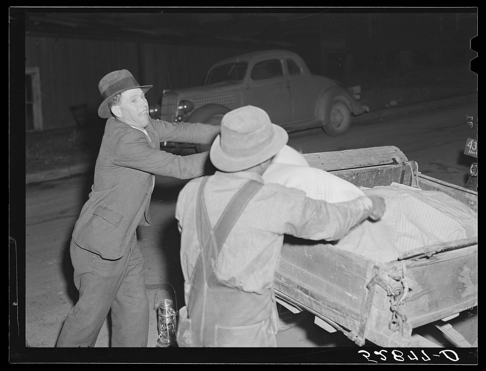 [Untitled photo, possibly related to: Mr. Elvin Wilkins fastening a new lantern on the back of his trailer in which he…