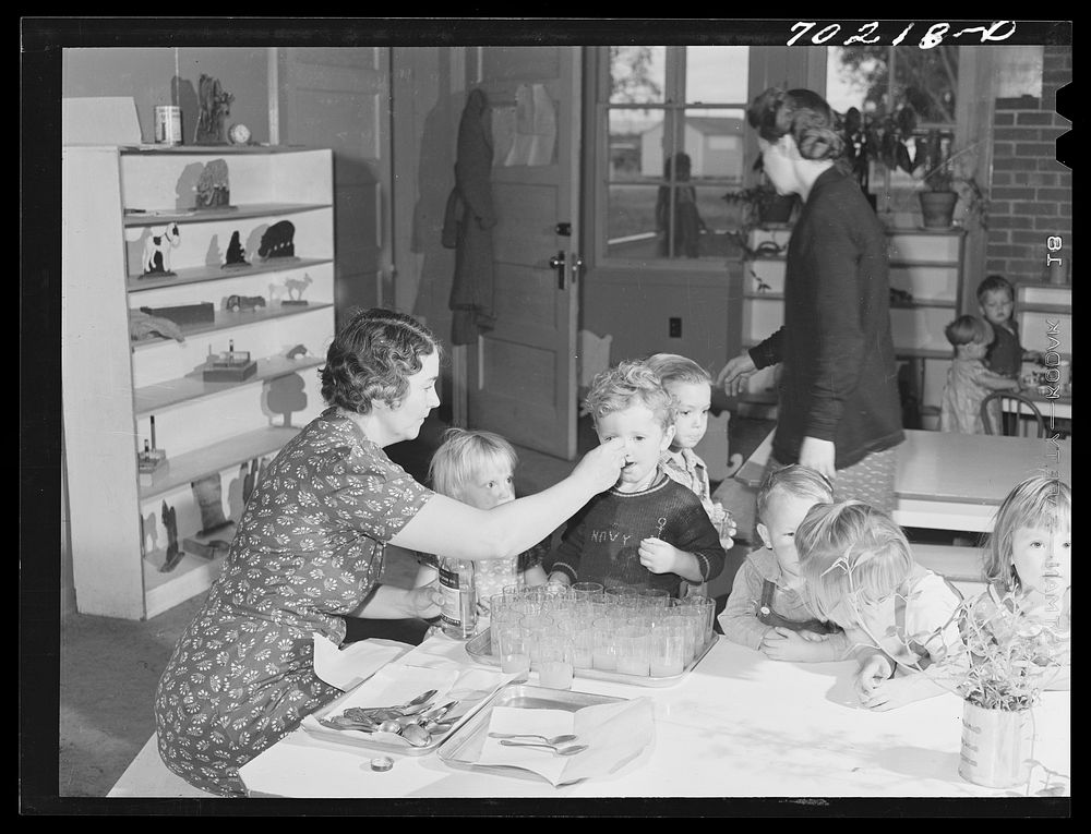 Cod liver oil and orange juice is fed to children at the nursery school at the FSA (Farm Security Administration) farm…