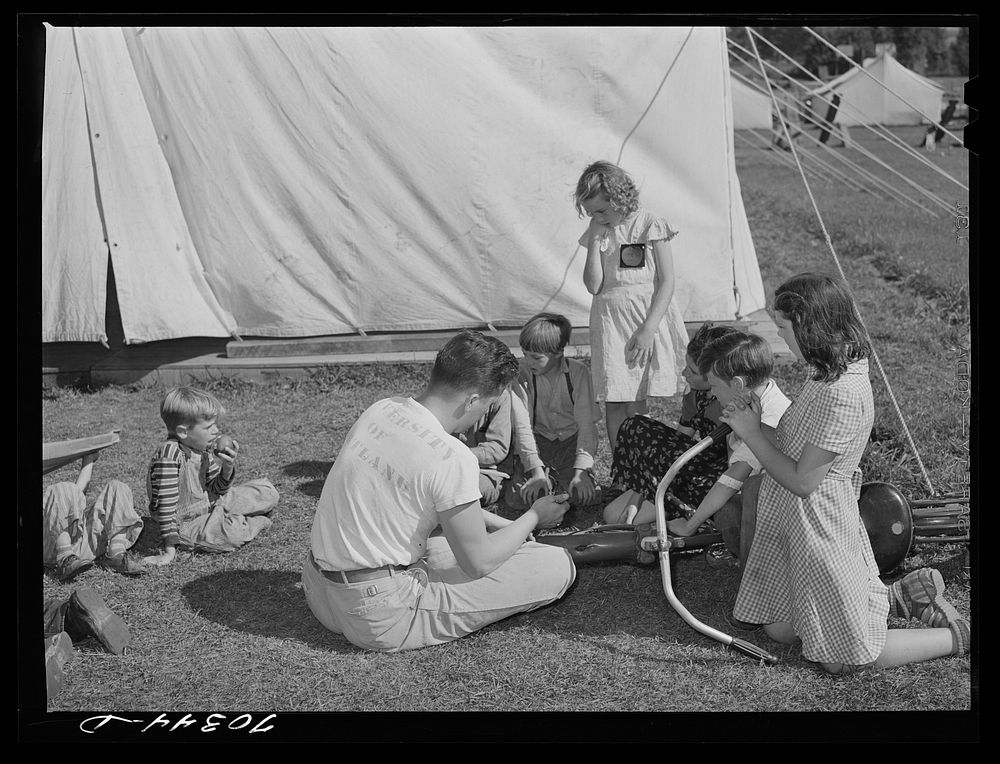 [Untitled photo, possibly related to: Repairing bicycle. FSA (Farm Security Administration) mobile camp for migratory farm…
