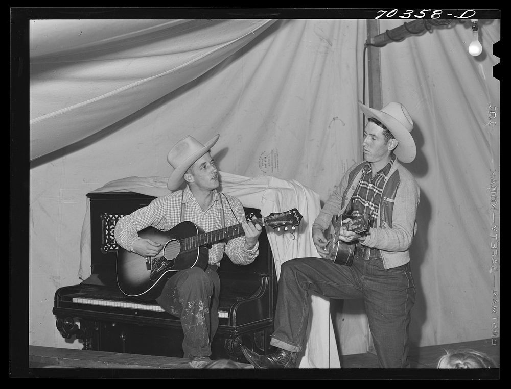 Singing cowboy songs at entertainment at the FSA (Farm Security Administration) mobile camp for migratory farm workers.…