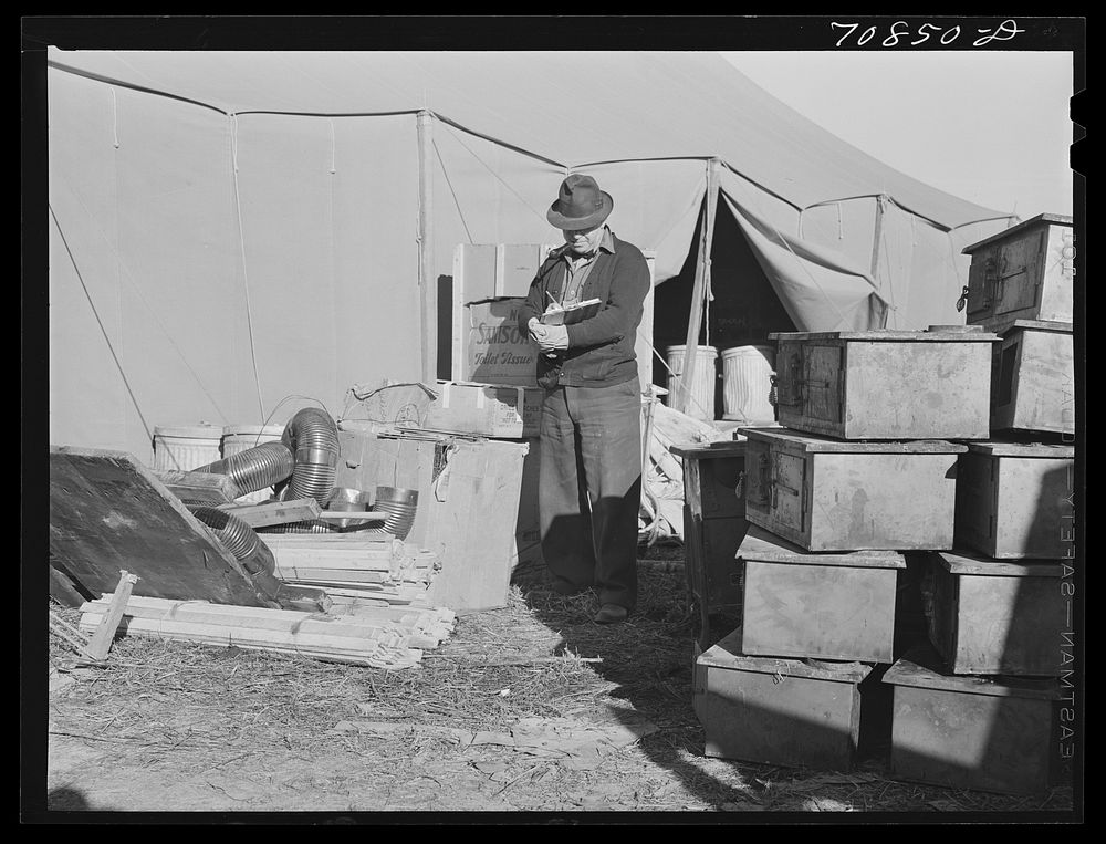 Checking in equipment from FSA (Farm Security Administration) mobile camps as it arrives at the FSA permanent camp at…