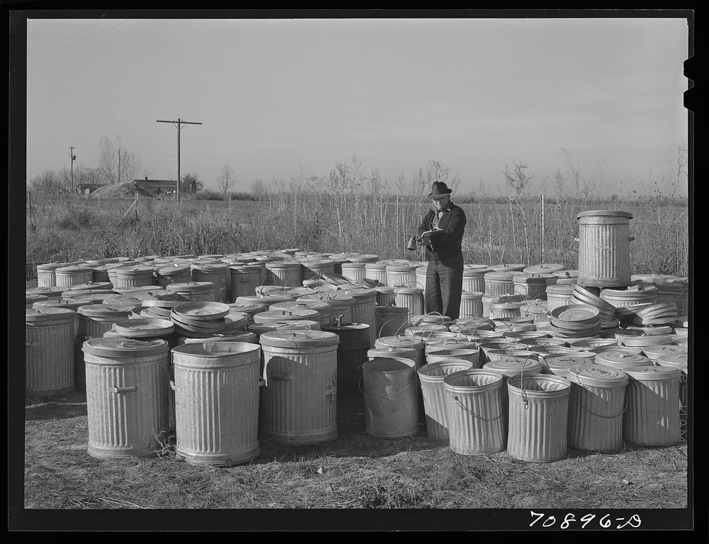 Checking in garbage cans from the FSA (Farm Security Administration) mobile camps at the permanent camp at Caldwell, Idaho…