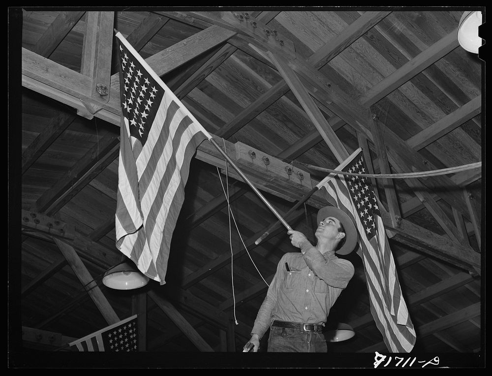 Tulare County, California. FSA (Farm Security Administration) farm workers' camp. Putting up flags for the President's…