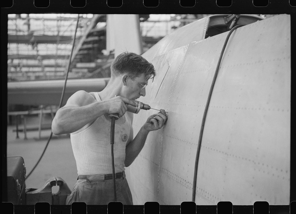 Nashville, Tennessee. Vultee Aircraft Company. Drilling holes for rivets in a fuselage on a sub-assembly line. Sourced from…