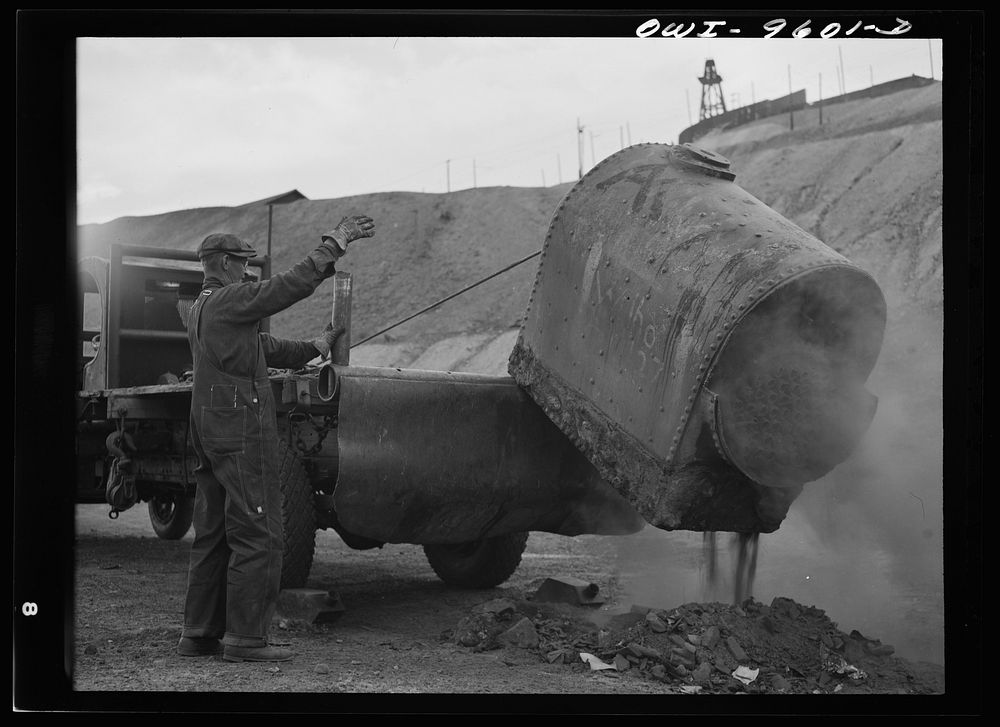 Butte, Montana. Loading part of an old boiler onto a truck during the scrap salvage campaign by Russell Lee