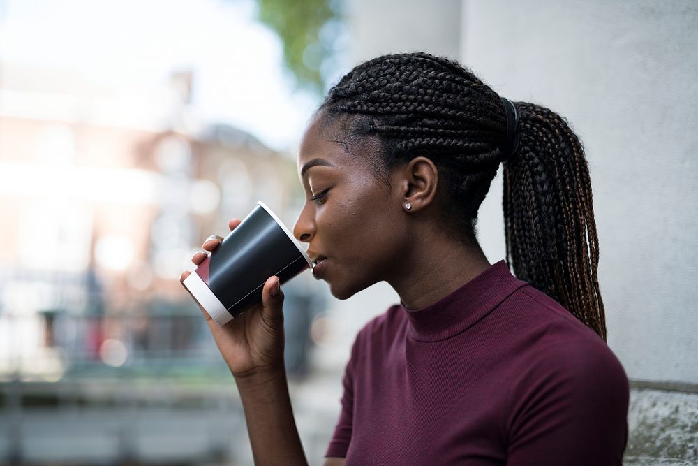 Woman drinking coffee out of a paper cup