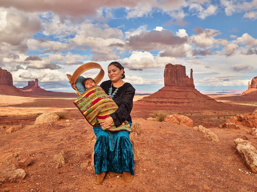 Navajo Eula Matene hold three-month-old Leon Clark on a ridge in the Arizona portion of Monument Valley, a red-sand desert…
