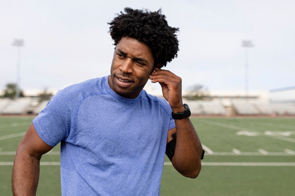 Man athlete putting the earbud on his ears