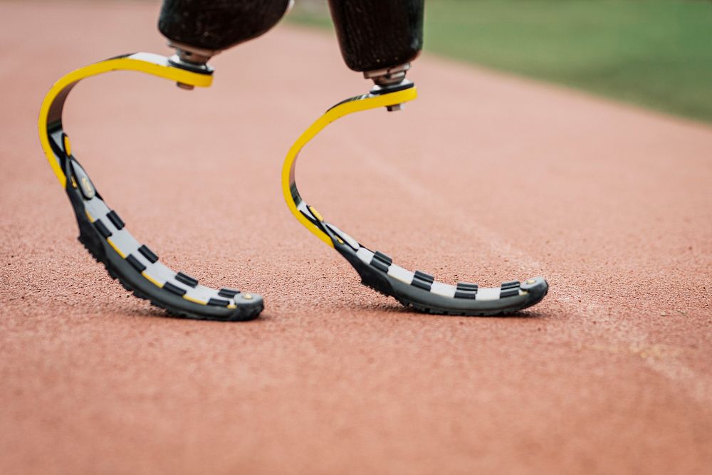 Athlete with prosthetic legs on a running track 