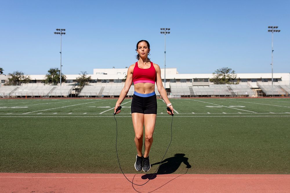 Woman athlete skipping rope in a stadium 