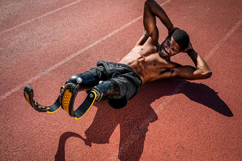 Male athlete with prosthetic legs crunching