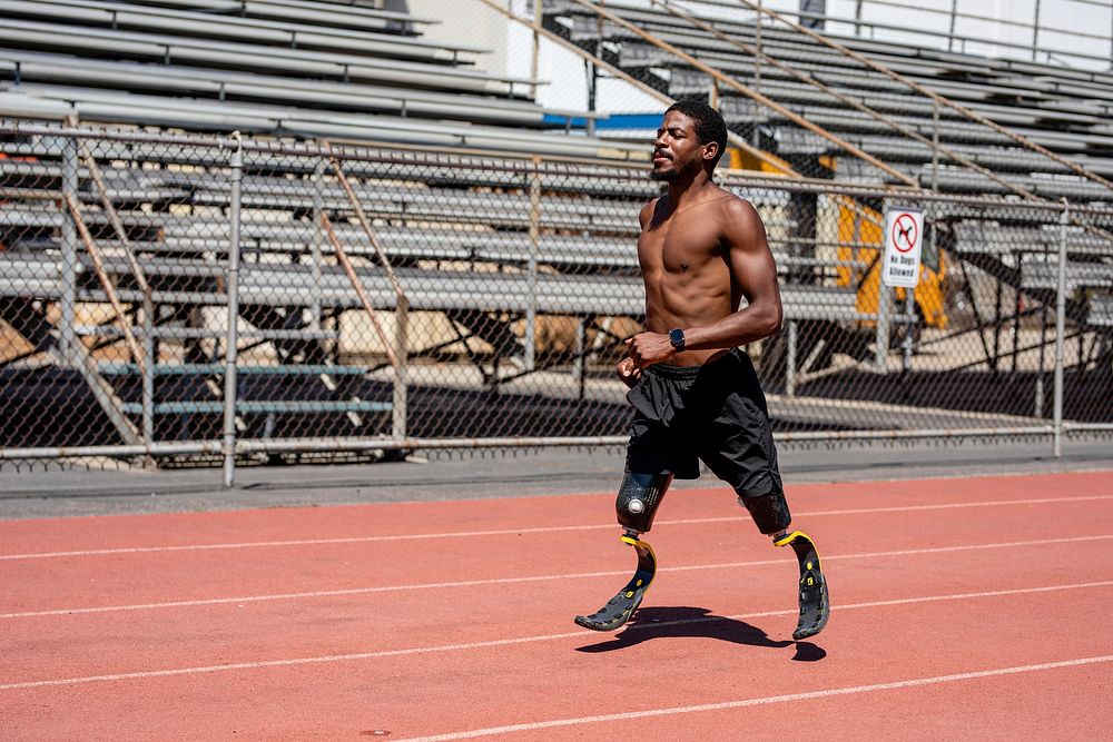 Man paralympic athlete running with prosthetic legs