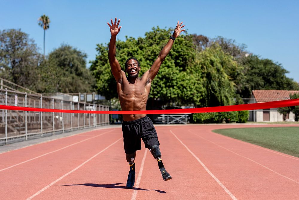 Black man runner winnning with arms open, athletic race competition
