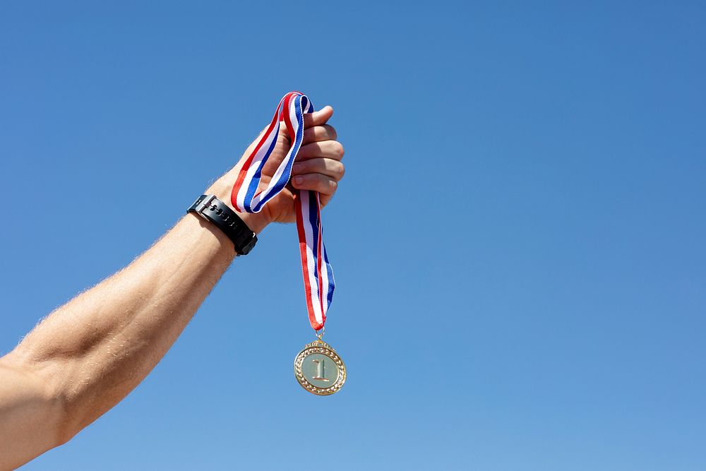 Man holding a gold medal after winning a race 