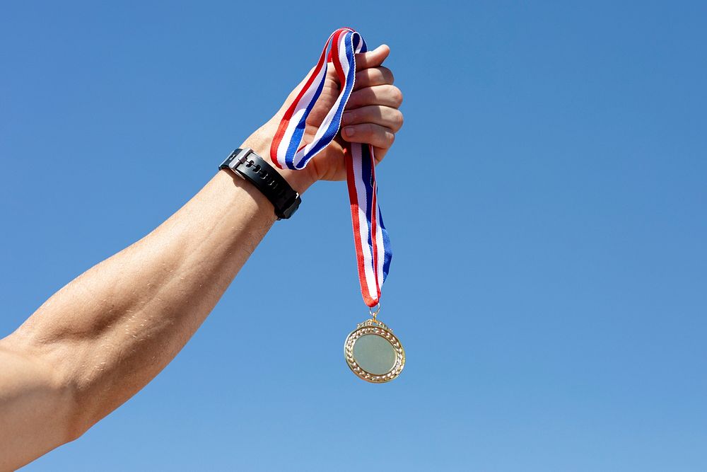 Man holding a gold medal after winning a race psd