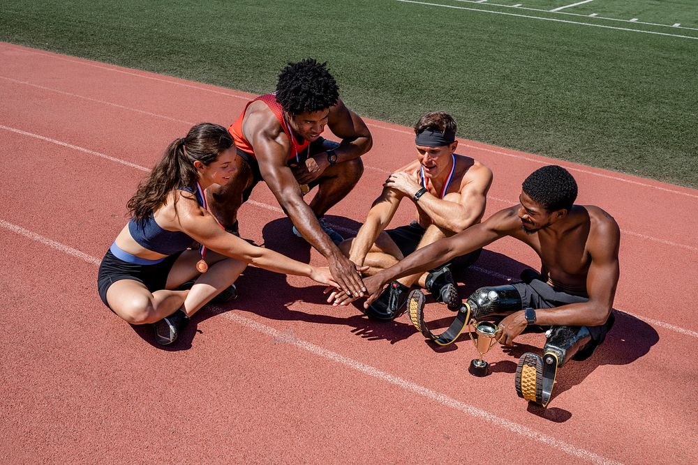 Team of diverse athletes stacking hand before the race
