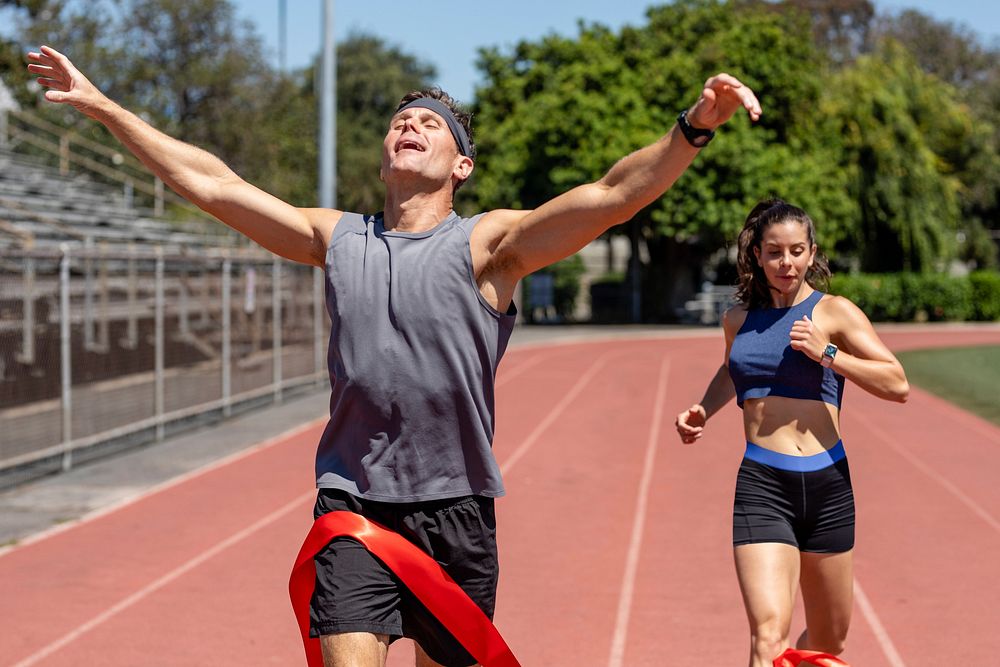 Man runner winnning with arms open, athletic race competition