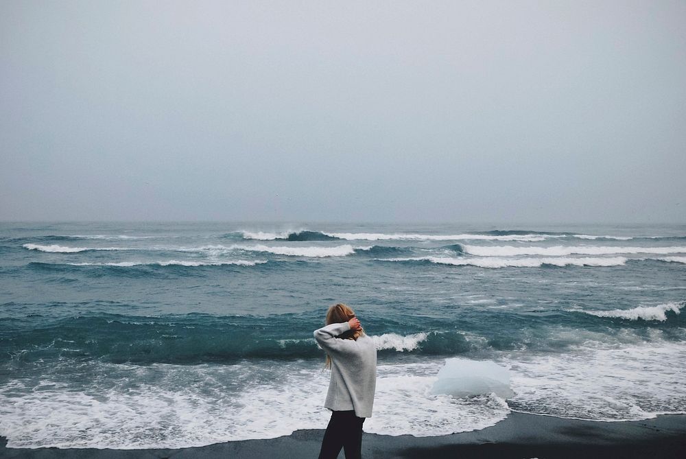 Woman standing by the sea, free public domain CC0 photo.