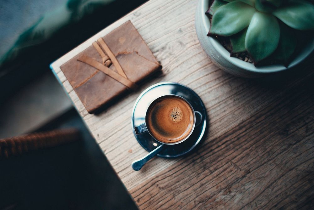 Free black coffee cup and note book on wooden table top view public domain CC0 photo.