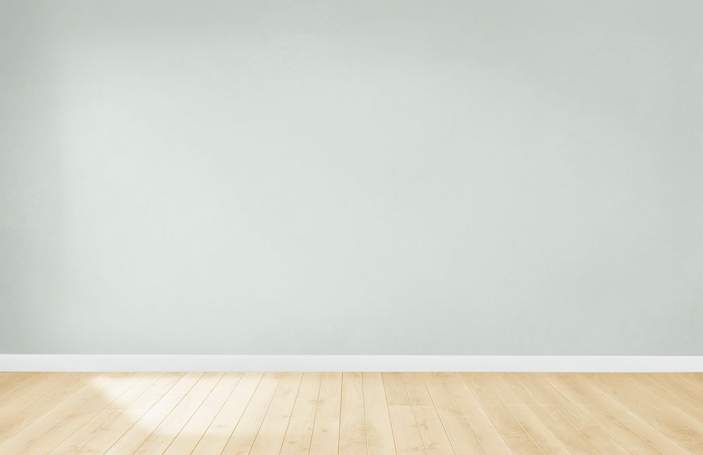 Light green wall in an empty room with a wooden floor