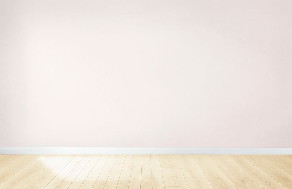 Light pink wall in an empty room with a wooden floor