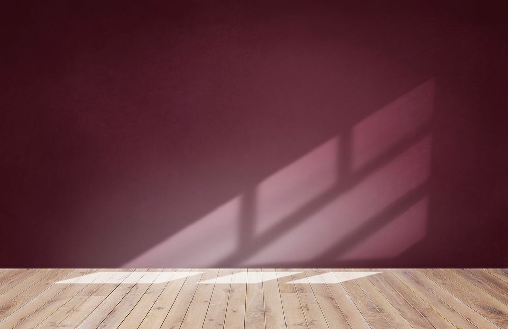 Burgundy red wall in an empty room with a wooden floor