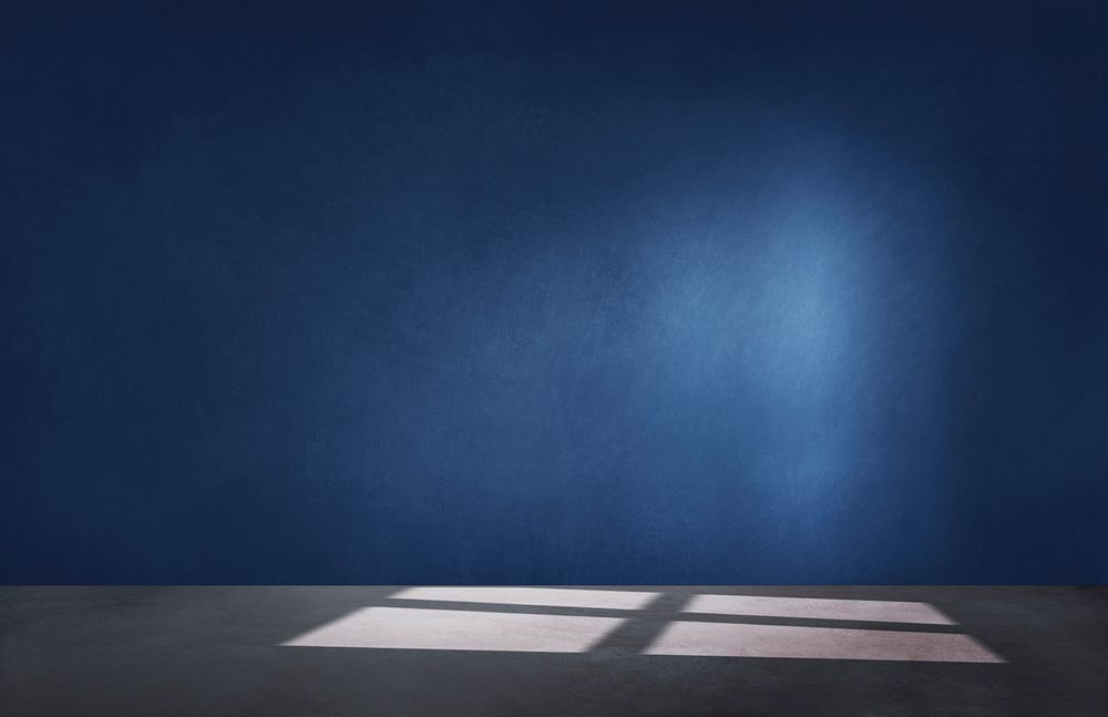 Dark blue wall in an empty room with a concrete floor
