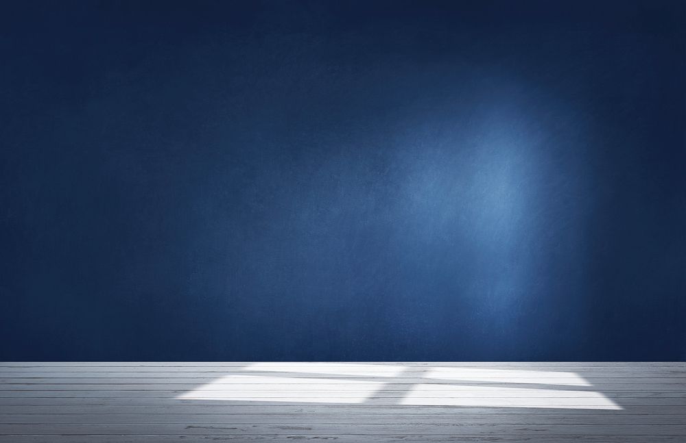 Dark blue wall in an empty room with a concrete floor