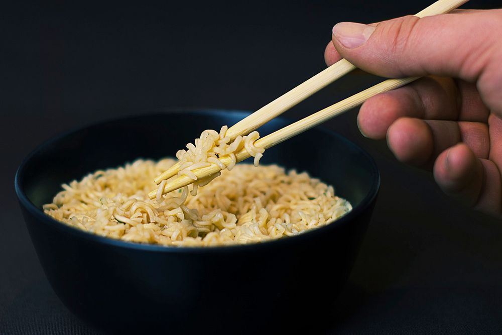 Free noodles, black bowl, chopsticks, with hands photo, public domain food CC0 image.