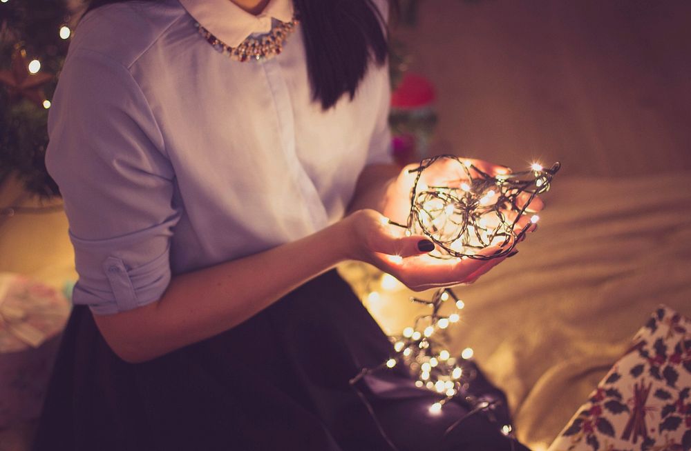 Woman holding Christmas string lights image, public domain decoration CC0 photo.