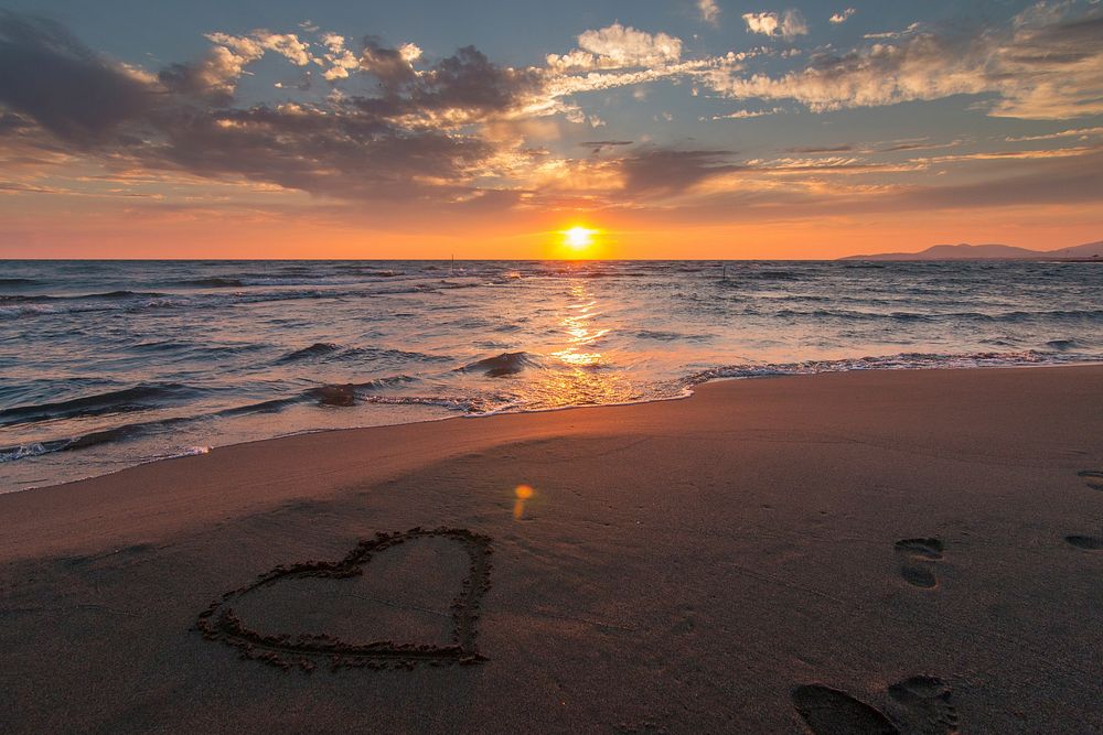 Heart shape on the sandy beach during sunset, free public domain CC0 photo.