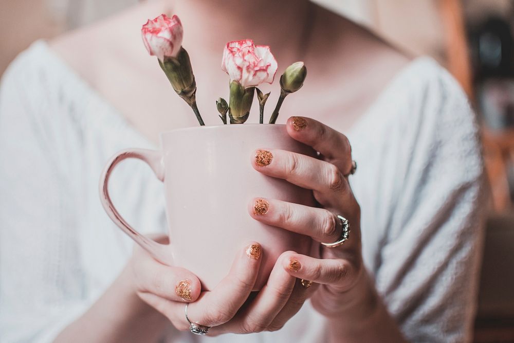 Free woman holds pink flower cup image, public domain people CC0 photo.