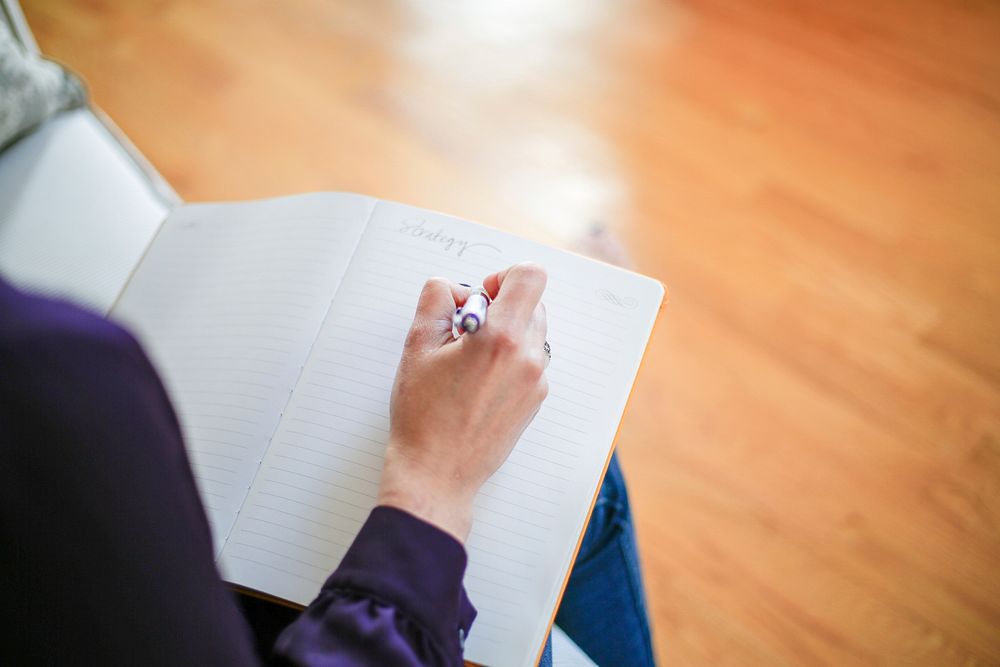 Free close up of a hand writing notes in a journal photo, public domain CC0 image.