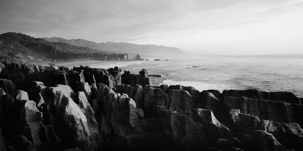 Panaroma of pancake rocks in the scenic view of mountains, beach and sunset.