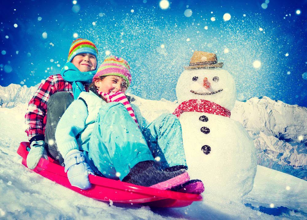 Little Girl and Boy Outdoors Sleding and Snowman
