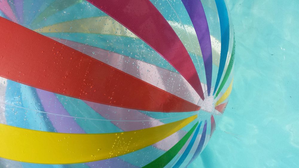 Free rainbow ball in swimming pool image, public domain CC0 photo.