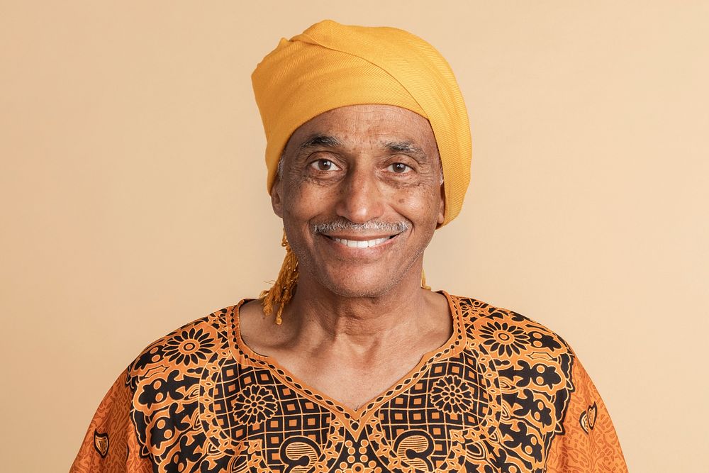 Happy mixed Indian senior man wearing a yellow turban