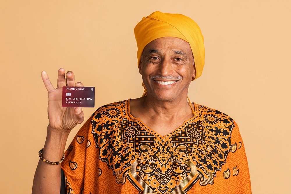 Happy mixed senior Indian man with a credit card 