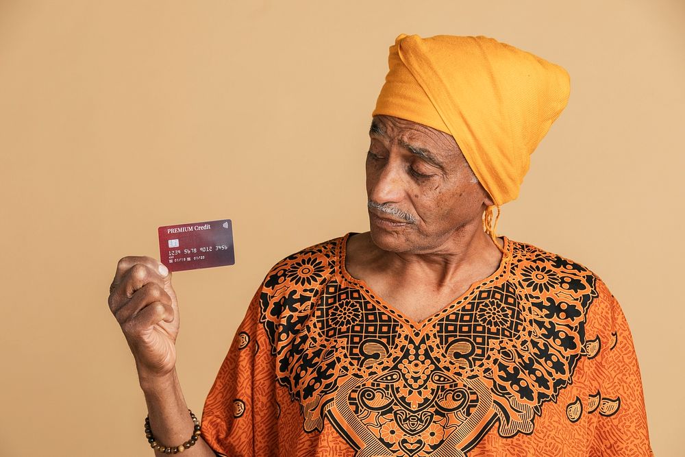 Skeptical mixed Indian man holding a credit card 
