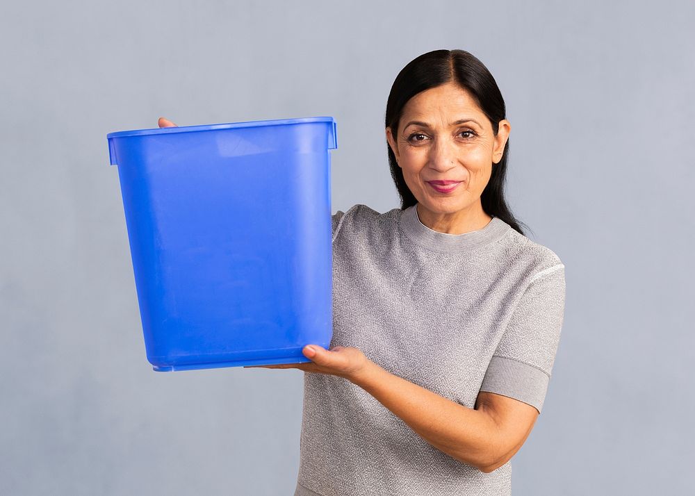 Senior Indian woman holding an empty blue container mockup