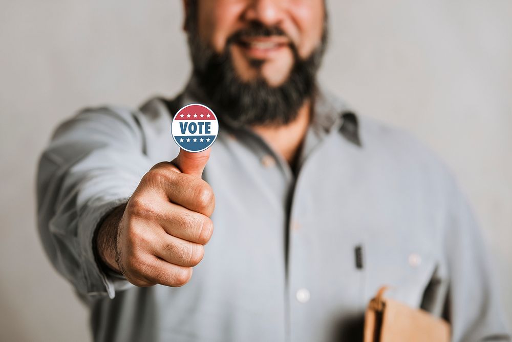 Bearded Indian man showing a vote sticker