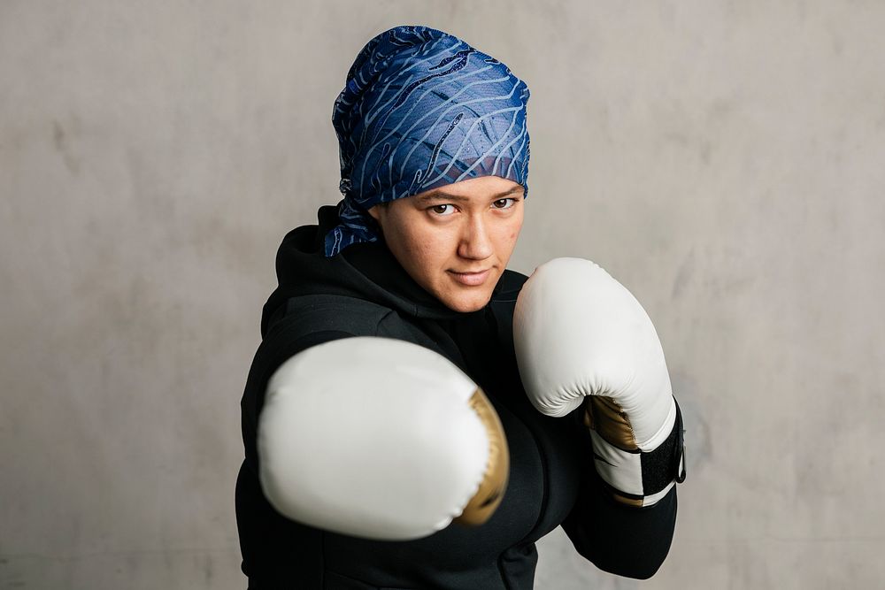 Young Islamic woman wearing a sport hijab while boxing 